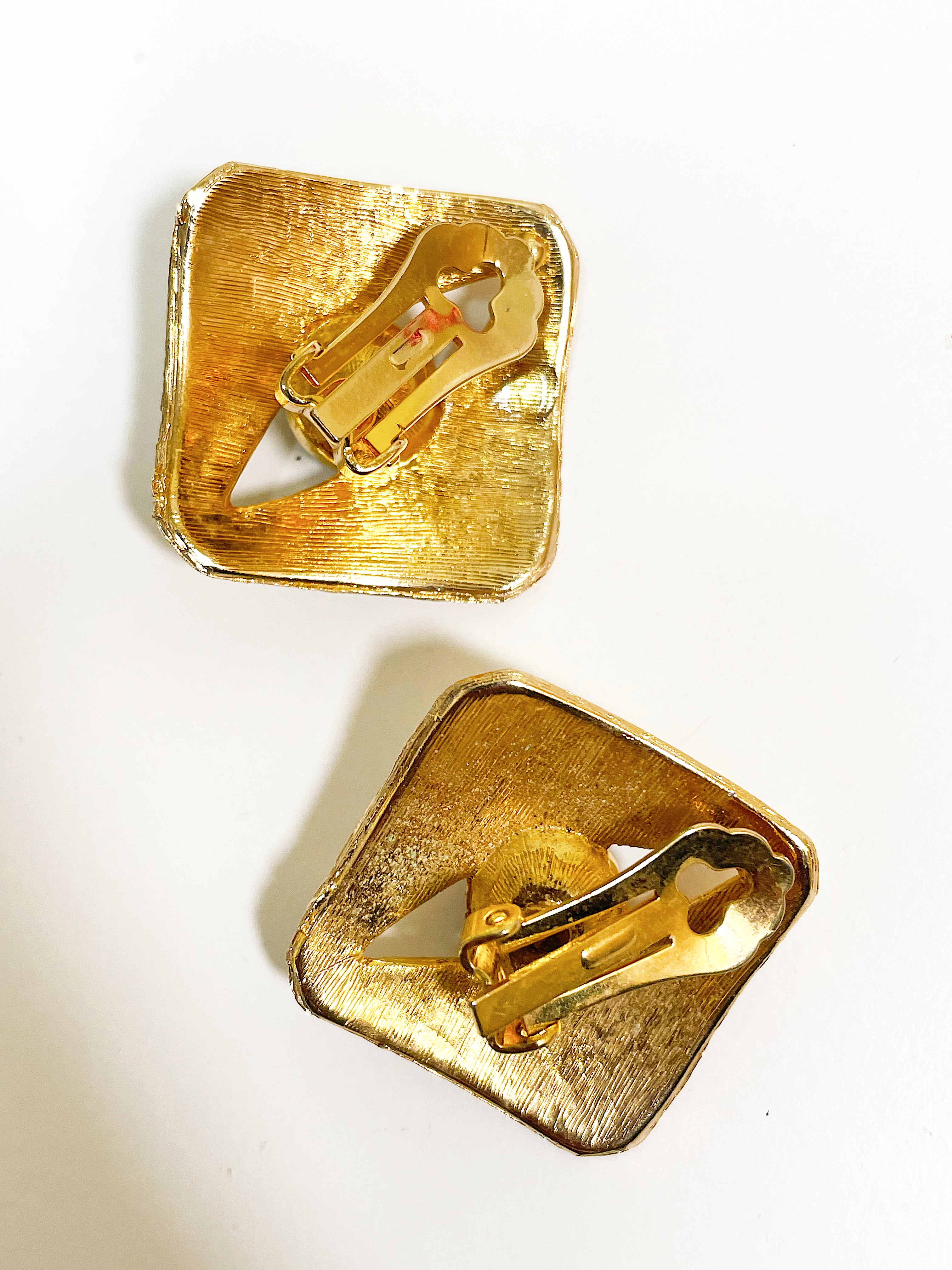 Large textured gold square earrings with black crystal stone.