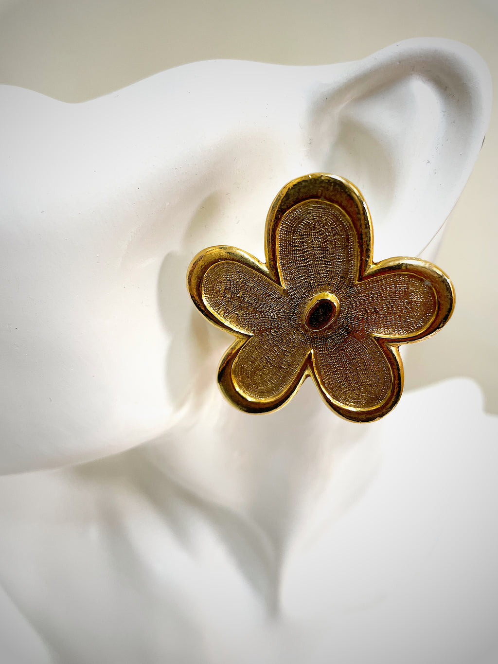 Oversized floral gold plated clip on statement earrings.