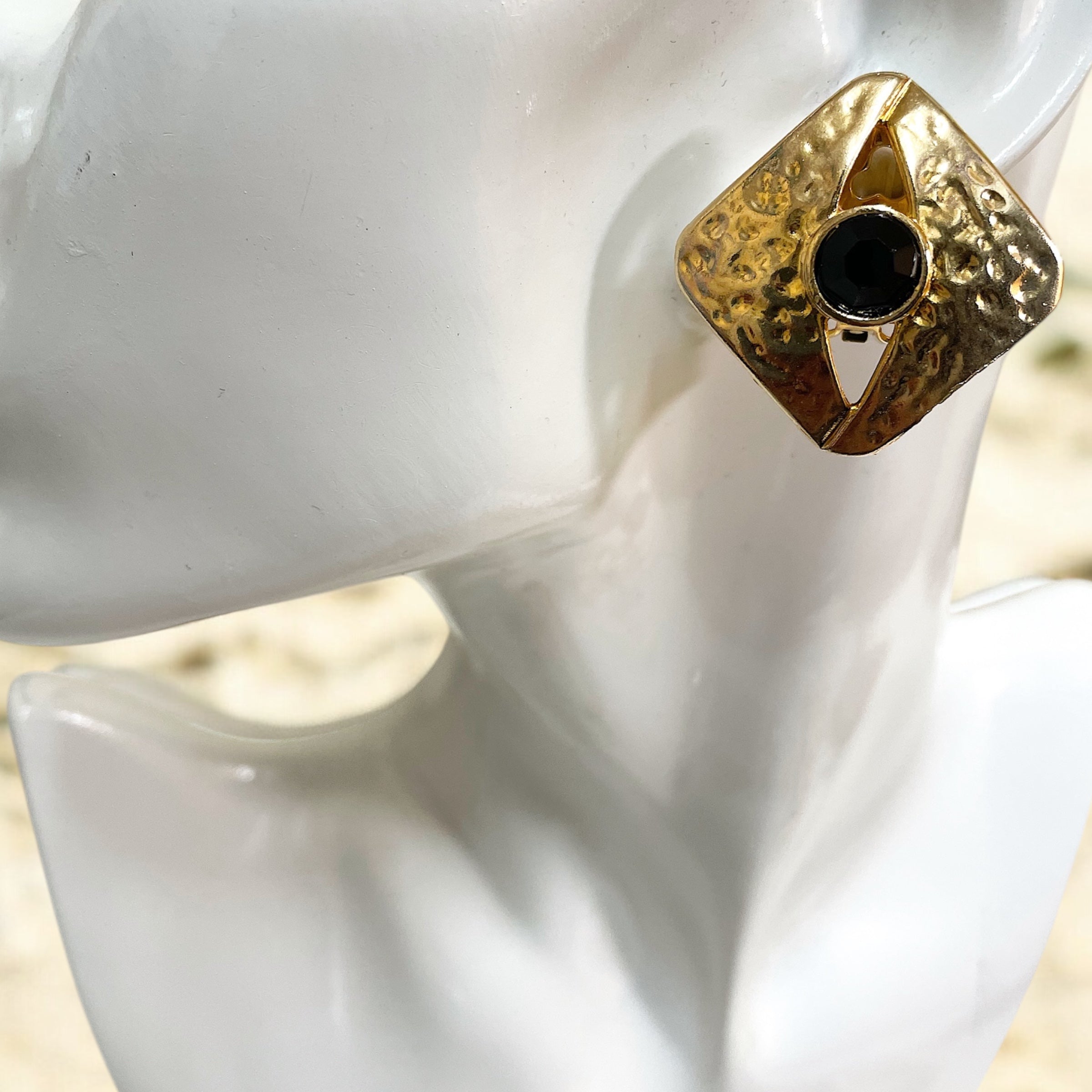 Large textured gold square earrings with black crystal stone.