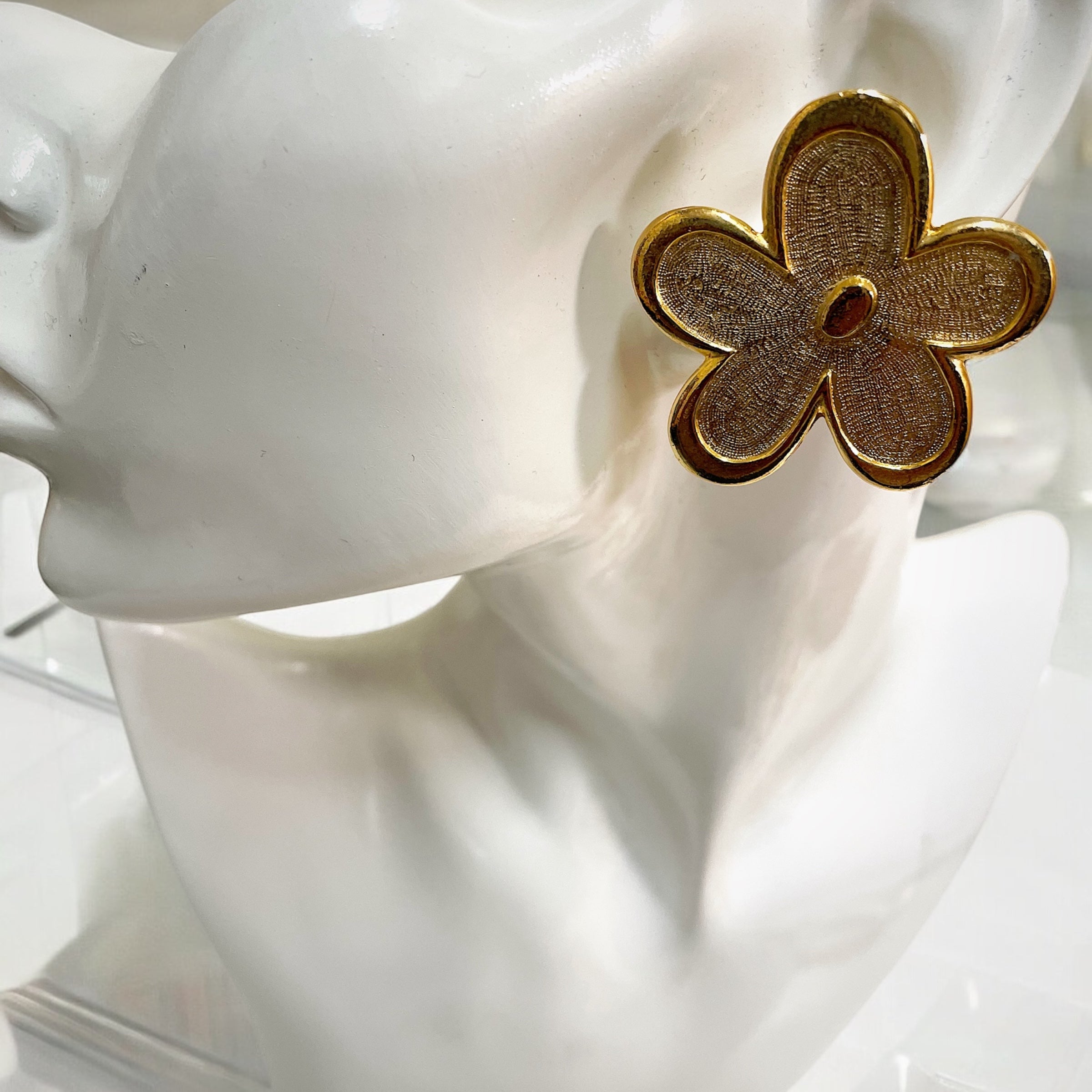 Oversized floral gold plated clip on statement earrings.